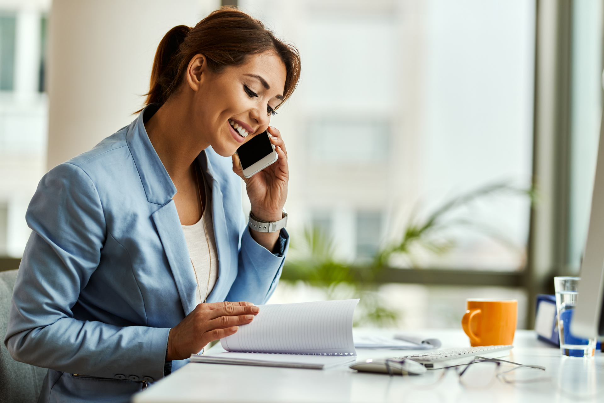 office staff member answering patient calls at a medical practice desk