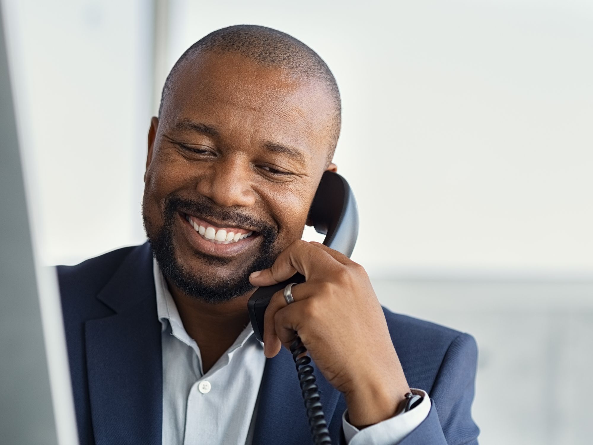 Friendly call center agent handling live call transfer with headset and telephone