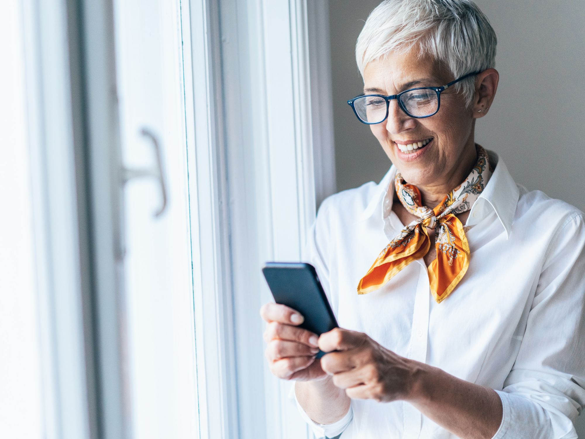 Smiling professional using smartphone for business text message dispatch communication